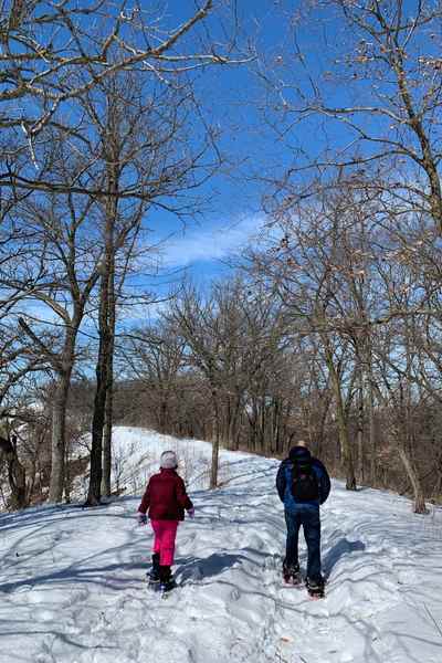 A father and daughter snowshoe at Hitchcock Nature Center in Honey Creek, Iowa