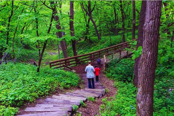 A mom and two kids walk toward a bridge at Dorothy Pecaut Nature Center Trail in Sioux City, Iowa